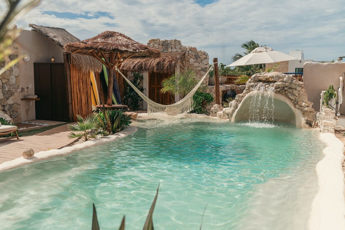 Alberca de arena con hamaca y palapa en la casa de playa de Viva Estancias en San Benito, Yucatán